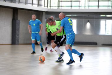Odessa, Ukrayna - 29 Mayıs 2020: 50 + gaziler arasında futsal kupa play-off maçı. Futsal, spor salonunun büyük sahnesinde, modern oyun alanını kapsıyor. Koridorda yoğun bir mini futbol maçı var. Parke üzerinde