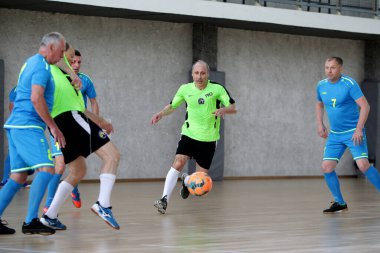 Odessa, Ukrayna - 29 Mayıs 2020: 50 + gaziler arasında futsal kupa play-off maçı. Futsal, spor salonunun büyük sahnesinde, modern oyun alanını kapsıyor. Koridorda yoğun bir mini futbol maçı var. Parke üzerinde