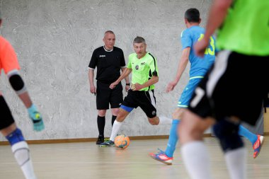 Odessa, Ukrayna - 29 Mayıs 2020: 50 + gaziler arasında futsal kupa play-off maçı. Futsal, spor salonunun büyük sahnesinde, modern oyun alanını kapsıyor. Koridorda yoğun bir mini futbol maçı var. Parke üzerinde