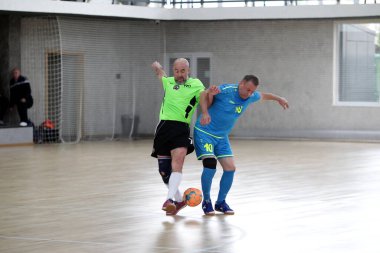 Odessa, Ukrayna - 29 Mayıs 2020: 50 + gaziler arasında futsal kupa play-off maçı. Futsal, spor salonunun büyük sahnesinde, modern oyun alanını kapsıyor. Koridorda yoğun bir mini futbol maçı var. Parke üzerinde
