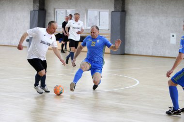 Odessa, Ukrayna - 29 Mayıs 2020: 50 + gaziler arasında futsal kupa play-off maçı. Futsal, spor salonunun büyük sahnesinde, modern oyun alanını kapsıyor. Koridorda yoğun bir mini futbol maçı var. Parke üzerinde