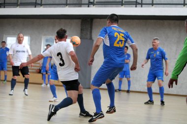 Odessa, Ukrayna - 29 Mayıs 2020: 50 + gaziler arasında futsal kupa play-off maçı. Futsal, spor salonunun büyük sahnesinde, modern oyun alanını kapsıyor. Koridorda yoğun bir mini futbol maçı var. Parke üzerinde