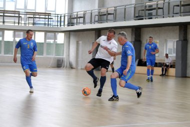 Odessa, Ukrayna - 29 Mayıs 2020: 50 + gaziler arasında futsal kupa play-off maçı. Futsal, spor salonunun büyük sahnesinde, modern oyun alanını kapsıyor. Koridorda yoğun bir mini futbol maçı var. Parke üzerinde