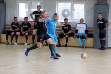 Odessa, Ukrayna - 29 Mayıs 2020: 50 + gaziler arasında futsal kupa play-off maçı. Futsal, spor salonunun büyük sahnesinde, modern oyun alanını kapsıyor. Koridorda yoğun bir mini futbol maçı var. Parke üzerinde