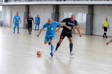 Odessa, Ukrayna - 29 Mayıs 2020: 50 + gaziler arasında futsal kupa play-off maçı. Futsal, spor salonunun büyük sahnesinde, modern oyun alanını kapsıyor. Koridorda yoğun bir mini futbol maçı var. Parke üzerinde