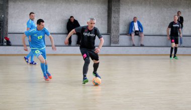 Odessa, Ukrayna - 29 Mayıs 2020: 50 + gaziler arasında futsal kupa play-off maçı. Futsal, spor salonunun büyük sahnesinde, modern oyun alanını kapsıyor. Koridorda yoğun bir mini futbol maçı var. Parke üzerinde