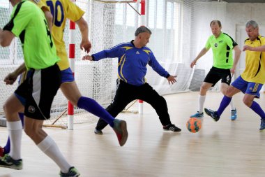 Odessa, Ukrayna - 29 Mayıs 2020: 50 + gaziler arasında futsal kupa play-off maçı. Futsal, spor salonunun büyük sahnesinde, modern oyun alanını kapsıyor. Koridorda yoğun bir mini futbol maçı var. Parke üzerinde