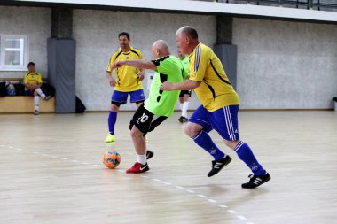 Odessa, Ukrayna - 29 Mayıs 2020: 50 + gaziler arasında futsal kupa play-off maçı. Futsal, spor salonunun büyük sahnesinde, modern oyun alanını kapsıyor. Koridorda yoğun bir mini futbol maçı var. Parke üzerinde