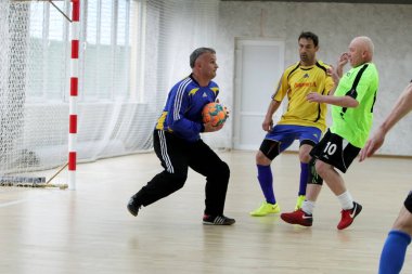 Odessa, Ukrayna - 29 Mayıs 2020: 50 + gaziler arasında futsal kupa play-off maçı. Futsal, spor salonunun büyük sahnesinde, modern oyun alanını kapsıyor. Koridorda yoğun bir mini futbol maçı var. Parke üzerinde