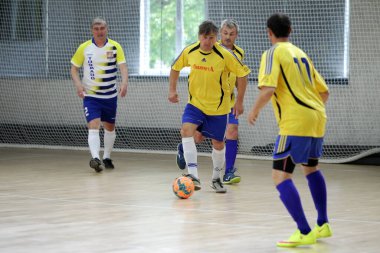 Odessa, Ukrayna - 29 Mayıs 2020: 50 + gaziler arasında futsal kupa play-off maçı. Futsal, spor salonunun büyük sahnesinde, modern oyun alanını kapsıyor. Koridorda yoğun bir mini futbol maçı var. Parke üzerinde