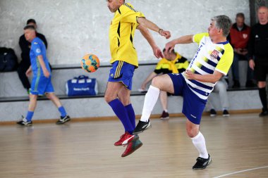 Odessa, Ukrayna - 29 Mayıs 2020: 50 + gaziler arasında futsal kupa play-off maçı. Futsal, spor salonunun büyük sahnesinde, modern oyun alanını kapsıyor. Koridorda yoğun bir mini futbol maçı var. Parke üzerinde