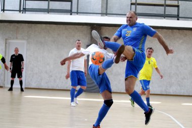 Odessa, Ukrayna - 29 Mayıs 2020: 50 + gaziler arasında futsal kupa play-off maçı. Futsal, spor salonunun büyük sahnesinde, modern oyun alanını kapsıyor. Koridorda yoğun bir mini futbol maçı var. Parke üzerinde