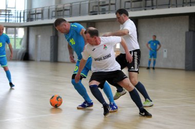 Odessa, Ukrayna - 29 Mayıs 2020: 50 + gaziler arasında futsal kupa play-off maçı. Futsal, spor salonunun büyük sahnesinde, modern oyun alanını kapsıyor. Koridorda yoğun bir mini futbol maçı var. Parke üzerinde