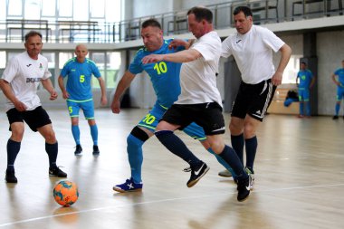 Odessa, Ukrayna - 29 Mayıs 2020: 50 + gaziler arasında futsal kupa play-off maçı. Futsal, spor salonunun büyük sahnesinde, modern oyun alanını kapsıyor. Koridorda yoğun bir mini futbol maçı var. Parke üzerinde
