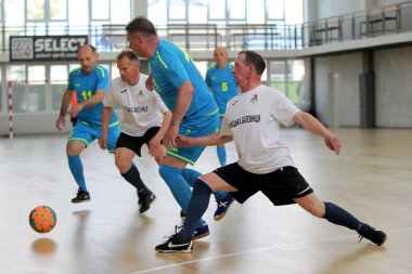 Odessa, Ukrayna - 29 Mayıs 2020: 50 + gaziler arasında futsal kupa play-off maçı. Futsal, spor salonunun büyük sahnesinde, modern oyun alanını kapsıyor. Koridorda yoğun bir mini futbol maçı var. Parke üzerinde