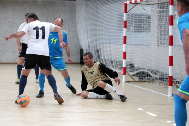 Odessa, Ukrayna - 29 Mayıs 2020: 50 + gaziler arasında futsal kupa play-off maçı. Futsal, spor salonunun büyük sahnesinde, modern oyun alanını kapsıyor. Koridorda yoğun bir mini futbol maçı var. Parke üzerinde