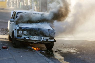 ODESSA, UKRAINE - 13 Ekim 2018: otobanın ortasında yanan araba. Eski bir arabaya kısa devre yaptırırken çıkan ani yangın. Motor bölmesindeki yangın bütün eski arabayı emmeye başladı. Trafik kazası.