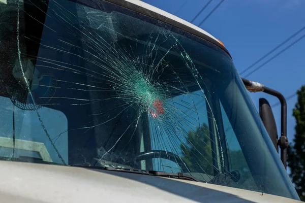 Broken car windshield. Web of radial cracks, crack on triple windshield. Broken windshield car, damaged glass with traces of an oncoming stone on road or trace of downed pedestrian or animal on road