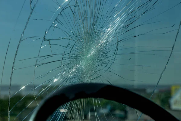 Broken car windshield. Web of radial cracks, crack on triple windshield. Broken windshield car, damaged glass with traces of an oncoming stone on road or trace of downed pedestrian or animal on road