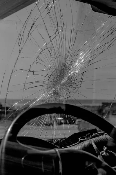 Broken car windshield. Web of radial cracks, crack on triple windshield. Broken windshield car, damaged glass with traces of an oncoming stone on road or trace of downed pedestrian or animal on road