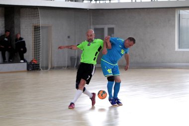 Odessa, Ukrayna - 29 Mayıs 2020: 50 + gaziler arasında futsal kupa play-off maçı. Futsal, spor salonunun büyük sahnesinde, modern oyun alanını kapsıyor. Koridorda yoğun bir mini futbol maçı var. Parke üzerinde