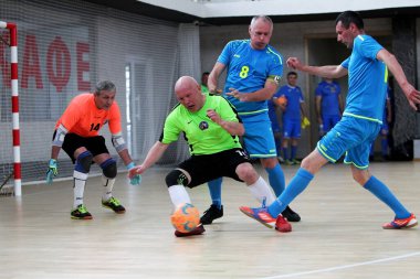 Odessa, Ukrayna - 29 Mayıs 2020: 50 + gaziler arasında futsal kupa play-off maçı. Futsal, spor salonunun büyük sahnesinde, modern oyun alanını kapsıyor. Koridorda yoğun bir mini futbol maçı var. Parke üzerinde