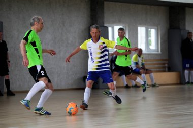 Odessa, Ukrayna - 29 Mayıs 2020: 50 + gaziler arasında futsal kupa play-off maçı. Futsal, spor salonunun büyük sahnesinde, modern oyun alanını kapsıyor. Koridorda yoğun bir mini futbol maçı var. Parke üzerinde