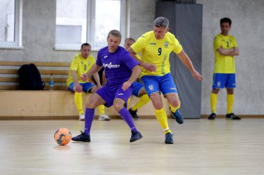 Odessa, Ukrayna - 29 Mayıs 2020: 50 + gaziler arasında futsal kupa play-off maçı. Futsal, spor salonunun büyük sahnesinde, modern oyun alanını kapsıyor. Koridorda yoğun bir mini futbol maçı var. Parke üzerinde