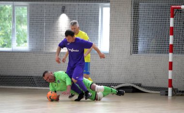 Odessa, Ukrayna - 29 Mayıs 2020: 50 + gaziler arasında futsal kupa play-off maçı. Futsal, spor salonunun büyük sahnesinde, modern oyun alanını kapsıyor. Koridorda yoğun bir mini futbol maçı var. Parke üzerinde