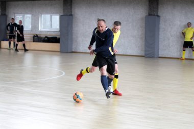 Odessa, Ukrayna - 29 Mayıs 2020: 50 + gaziler arasında futsal kupa play-off maçı. Futsal, spor salonunun büyük sahnesinde, modern oyun alanını kapsıyor. Koridorda yoğun bir mini futbol maçı var. Parke üzerinde