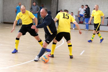 Odessa, Ukrayna - 29 Mayıs 2020: 50 + gaziler arasında futsal kupa play-off maçı. Futsal, spor salonunun büyük sahnesinde, modern oyun alanını kapsıyor. Koridorda yoğun bir mini futbol maçı var. Parke üzerinde