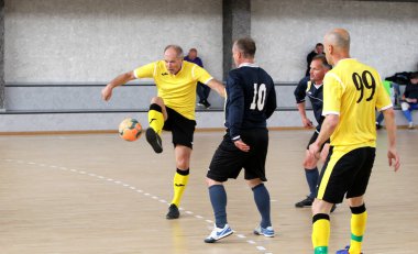 Odessa, Ukrayna - 29 Mayıs 2020: 50 + gaziler arasında futsal kupa play-off maçı. Futsal, spor salonunun büyük sahnesinde, modern oyun alanını kapsıyor. Koridorda yoğun bir mini futbol maçı var. Parke üzerinde