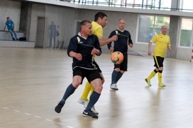 Odessa, Ukrayna - 29 Mayıs 2020: 50 + gaziler arasında futsal kupa play-off maçı. Futsal, spor salonunun büyük sahnesinde, modern oyun alanını kapsıyor. Koridorda yoğun bir mini futbol maçı var. Parke üzerinde