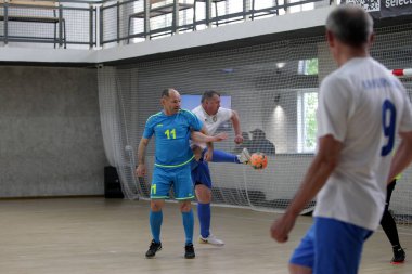Odessa, Ukrayna - 29 Mayıs 2020: 50 + gaziler arasında futsal kupa play-off maçı. Futsal, spor salonunun büyük sahnesinde, modern oyun alanını kapsıyor. Koridorda yoğun bir mini futbol maçı var. Parke üzerinde