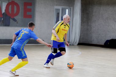 Odessa, Ukrayna - 29 Mayıs 2020: 50 + gaziler arasında futsal kupa play-off maçı. Futsal, spor salonunun büyük sahnesinde, modern oyun alanını kapsıyor. Koridorda yoğun bir mini futbol maçı var. Parke üzerinde