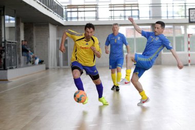 Odessa, Ukrayna - 29 Mayıs 2020: 50 + gaziler arasında futsal kupa play-off maçı. Futsal, spor salonunun büyük sahnesinde, modern oyun alanını kapsıyor. Koridorda yoğun bir mini futbol maçı var. Parke üzerinde