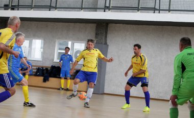 Odessa, Ukrayna - 29 Mayıs 2020: 50 + gaziler arasında futsal kupa play-off maçı. Futsal, spor salonunun büyük sahnesinde, modern oyun alanını kapsıyor. Koridorda yoğun bir mini futbol maçı var. Parke üzerinde