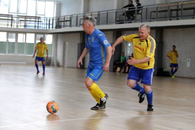 Odessa, Ukrayna - 29 Mayıs 2020: 50 + gaziler arasında futsal kupa play-off maçı. Futsal, spor salonunun büyük sahnesinde, modern oyun alanını kapsıyor. Koridorda yoğun bir mini futbol maçı var. Parke üzerinde