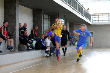 Odessa, Ukrayna - 29 Mayıs 2020: 50 + gaziler arasında futsal kupa play-off maçı. Futsal, spor salonunun büyük sahnesinde, modern oyun alanını kapsıyor. Koridorda yoğun bir mini futbol maçı var. Parke üzerinde