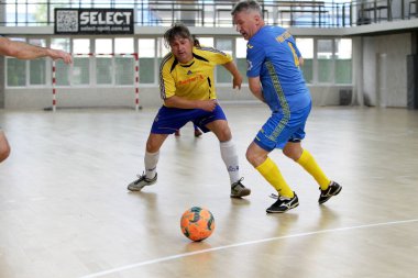Odessa, Ukrayna - 29 Mayıs 2020: 50 + gaziler arasında futsal kupa play-off maçı. Futsal, spor salonunun büyük sahnesinde, modern oyun alanını kapsıyor. Koridorda yoğun bir mini futbol maçı var. Parke üzerinde