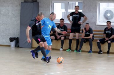 Odessa, Ukrayna - 29 Mayıs 2020: 50 + gaziler arasında futsal kupa play-off maçı. Futsal, spor salonunun büyük sahnesinde, modern oyun alanını kapsıyor. Koridorda yoğun bir mini futbol maçı var. Parke üzerinde