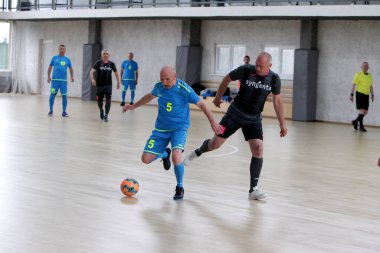 Odessa, Ukrayna - 29 Mayıs 2020: 50 + gaziler arasında futsal kupa play-off maçı. Futsal, spor salonunun büyük sahnesinde, modern oyun alanını kapsıyor. Koridorda yoğun bir mini futbol maçı var. Parke üzerinde