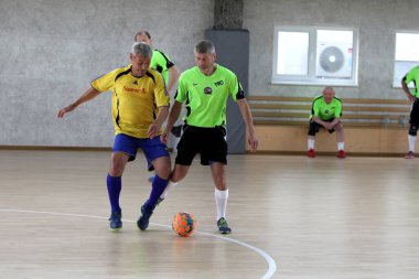 Odessa, Ukrayna - 29 Mayıs 2020: 50 + gaziler arasında futsal kupa play-off maçı. Futsal, spor salonunun büyük sahnesinde, modern oyun alanını kapsıyor. Koridorda yoğun bir mini futbol maçı var. Parke üzerinde