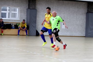 Odessa, Ukrayna - 29 Mayıs 2020: 50 + gaziler arasında futsal kupa play-off maçı. Futsal, spor salonunun büyük sahnesinde, modern oyun alanını kapsıyor. Koridorda yoğun bir mini futbol maçı var. Parke üzerinde