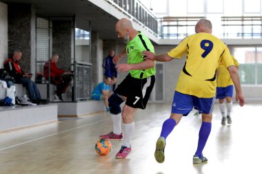 Odessa, Ukrayna - 29 Mayıs 2020: 50 + gaziler arasında futsal kupa play-off maçı. Futsal, spor salonunun büyük sahnesinde, modern oyun alanını kapsıyor. Koridorda yoğun bir mini futbol maçı var. Parke üzerinde