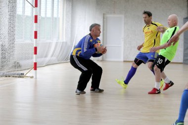 Odessa, Ukrayna - 29 Mayıs 2020: 50 + gaziler arasında futsal kupa play-off maçı. Futsal, spor salonunun büyük sahnesinde, modern oyun alanını kapsıyor. Koridorda yoğun bir mini futbol maçı var. Parke üzerinde
