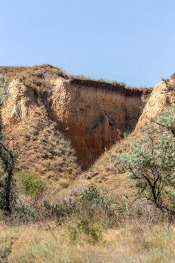 Çevreye zararlı bir bölgede dağ heyelan. Yeryüzündeki büyük çatlaklar, toprak yolu kapatan büyük katmanların inişi. Dağ yamacının yamacında baraj tehlikesi