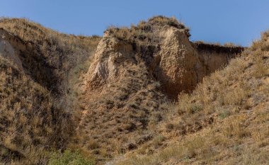 Çevreye zararlı bir bölgede dağ heyelan. Yeryüzündeki büyük çatlaklar, toprak yolu kapatan büyük katmanların inişi. Dağ yamacının yamacında baraj tehlikesi