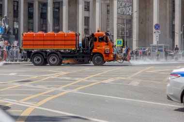 MOSCOW, RUSSIA - 24 Haziran 2020: Moskova şehir merkezindeki caddeleri COVID-19 Coronavirüs salgını sırasında dezenfekte ediyor. Sokak sulama makinesi şehir yolundaki asfaltı yıkıyor.