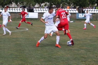 ODESSA, UKRAINE - Ukrayna Şampiyonası 'ndaki birinci lig kulüplerinin dövüşü. FC BALKANY (Zorya) - FC VOLYNB (Lutsk) - kırmızı. Çimlerin üzerinde büyük futbol oynarken dramatik bir düello.